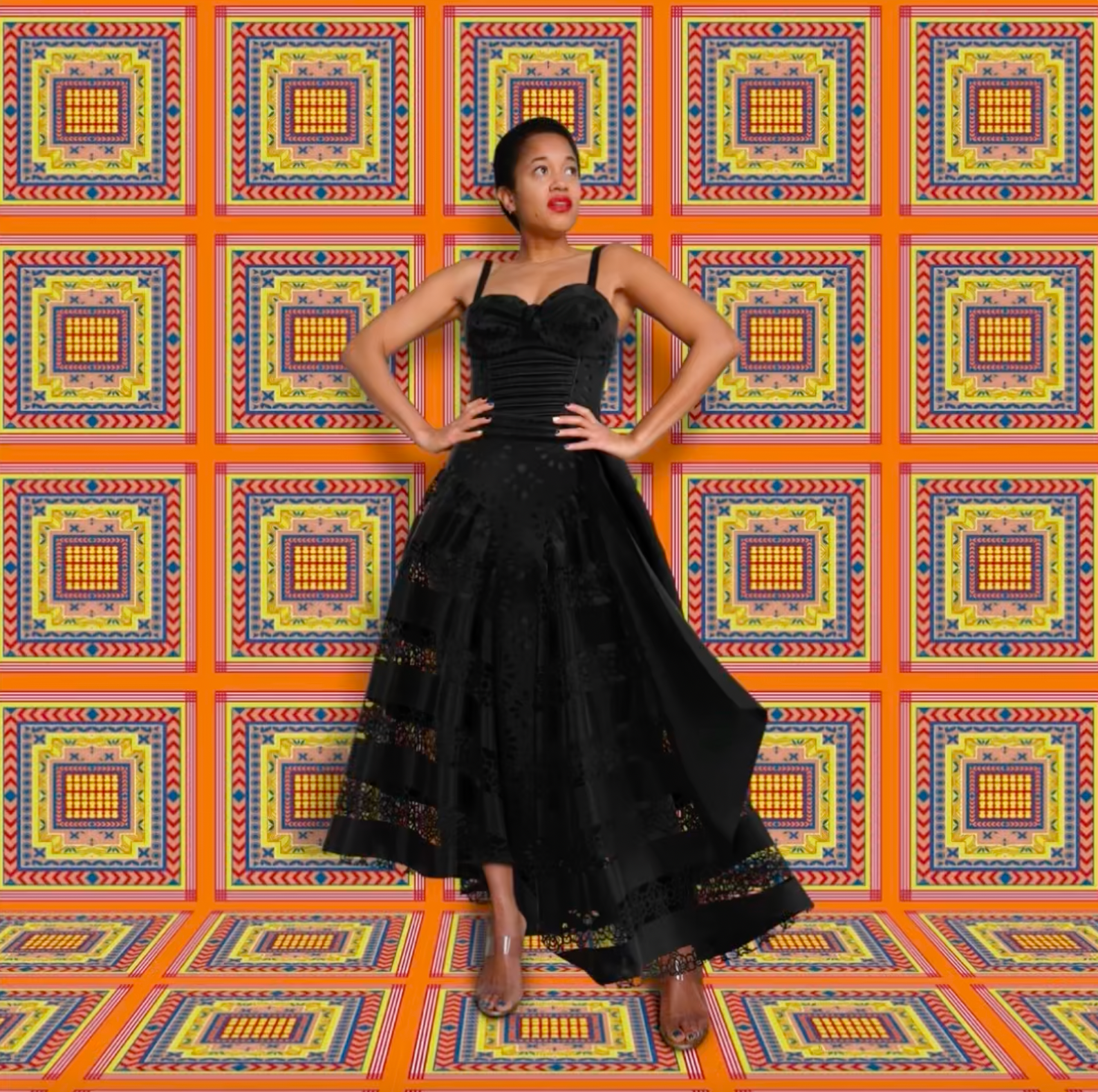 Journalist-turned-designer Anyango Mpinga on her vibrant eponymous label selling sustainable dresses that are irresistibly bold. Black evening dress. Bright orange background.