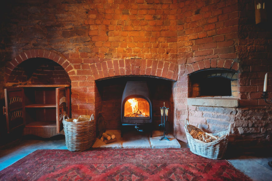 Cosy fire in a cottage. Cottage fireplace. If you're on the hunt for sustainable, dog-friendly hotels, travel to these destinations with four-legged friends in tow.