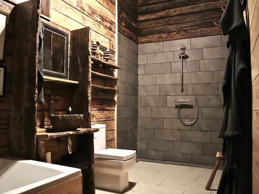 Bathroom in the Scottish highlands. black tiled bathroom. Exposed wood. If you're on the hunt for sustainable, dog-friendly hotels, travel to these destinations with four-legged friends in tow.