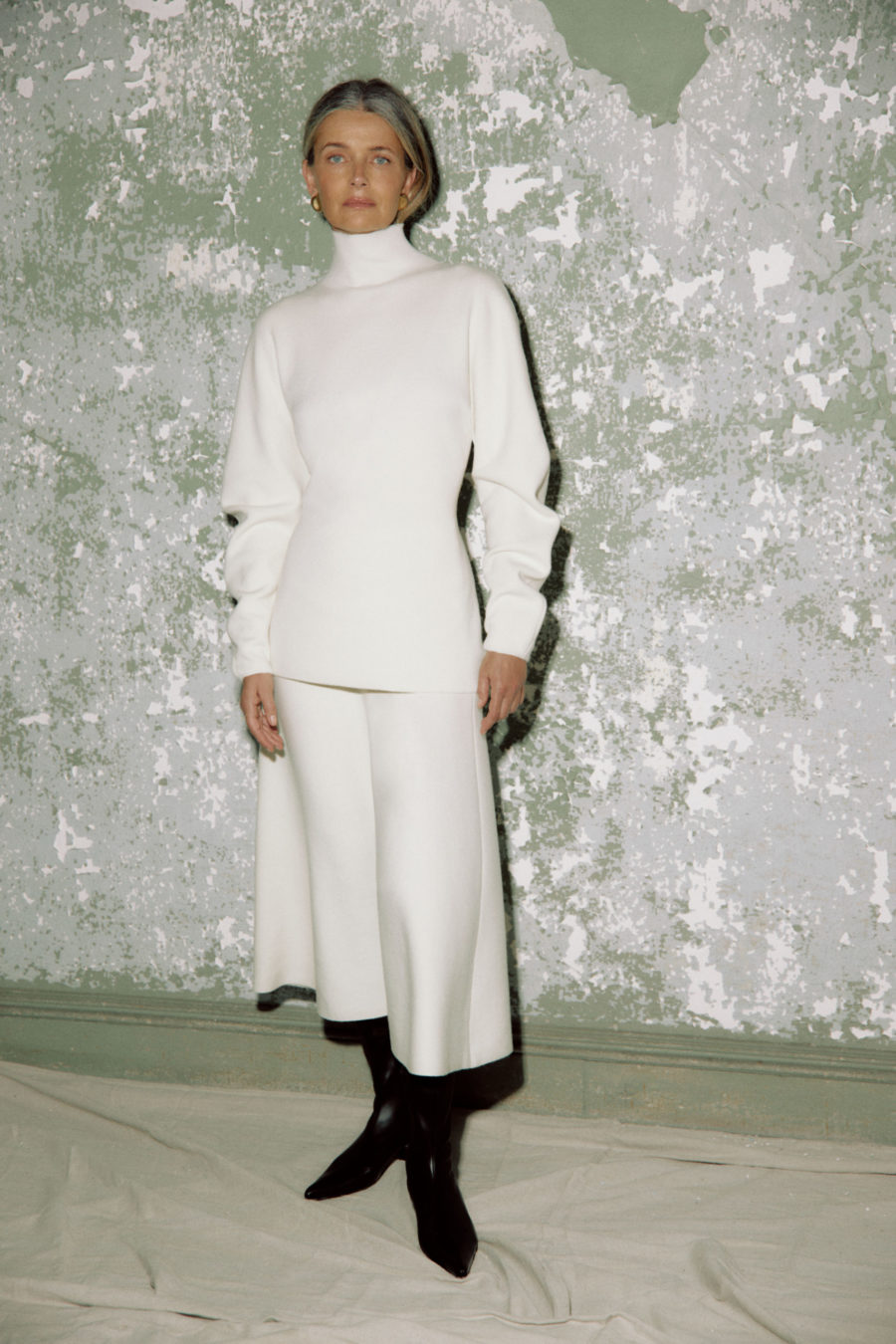 Woman wearing white turtleneck and skirt