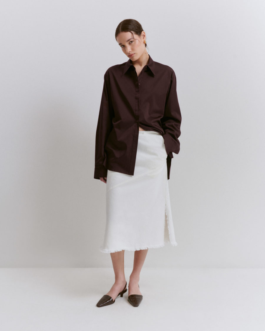 woman wearing brown blazer and shirt and white skirt